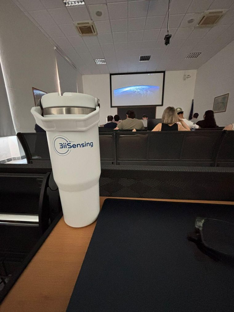 A BiiSensing tumbler in the foreground of the lecture hall at the University of Pisa Department of Earth Sciences, with a session in progress behind it
